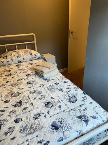 a bed with a blue and white comforter and pillows at Casa Lanza in Chioggia