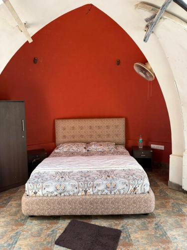 a bed in a room with an orange wall at Infinity Farm Grove in Olavakod Junction