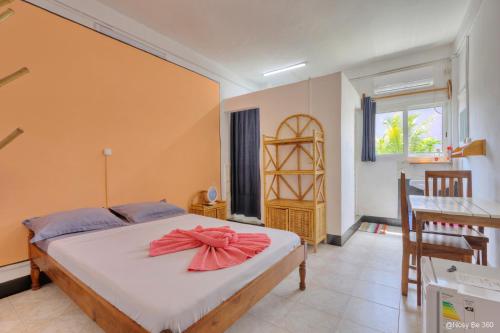 a bedroom with a bed with a red bow on it at VaoVao Hotel in Nosy Be
