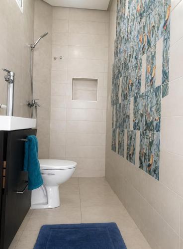 a bathroom with a toilet and a blue rug at Blue Escape in Oulad Teïma