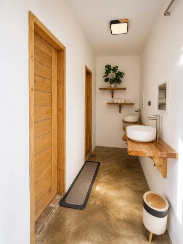 ein Badezimmer mit Holztür und Waschbecken in der Unterkunft MHARI Guest Rooms in San Juan