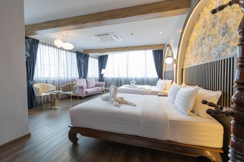 a bedroom with a large bed and a living room at Hotel Rue De Siam in Chinatown