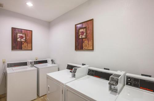 a laundry room with three washers and dryers at Country Inn & Suites by Radisson, Lewisville, TX in Lewisville