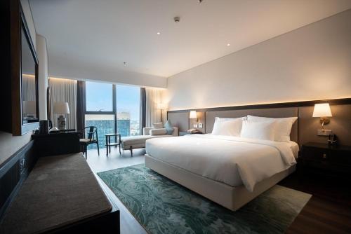 a bedroom with a large bed and a living room at Khách Sạn The Grand Dragon in Móng Cái
