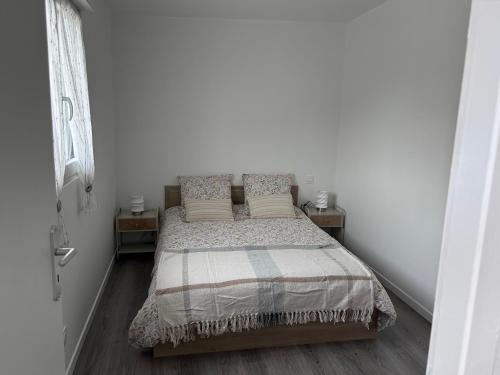 a bedroom with a bed with two night stands at le relais des étangs B in Mareuil-Caubert
