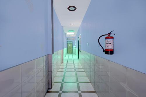 a hallway of a hospital with a fire extinguisher on the wall at Spot On Moonlight Hotel in Jhajjar