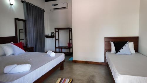 a room with two beds and a mirror in it at wild elephant reach wilpaththuwa in Nochchiyagama