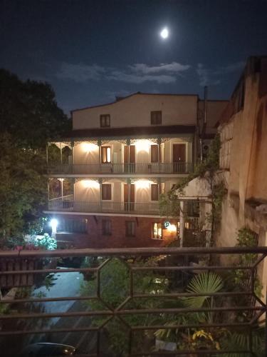 a building at night with the moon behind it at Hotel Zaira in Tbilisi City