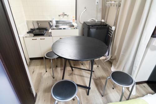 a small kitchen with a table and four chairs at Ijiri Relax stay in Fukuoka