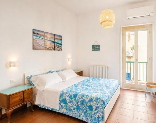 a bedroom with a bed and a table and a window at Casa Chicchella - Authentic Experience in Vieste