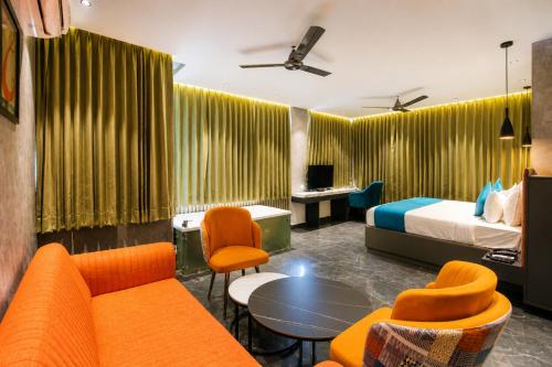 a hotel room with a bed and a couch and chairs at SKI Hotels and Resorts in Rishīkesh