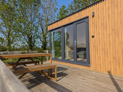 a house with a picnic table on a deck at Les Nids de Cerisy in Cerisy-la-Forêt