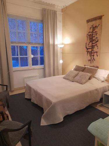 ein Schlafzimmer mit einem großen weißen Bett und einem Fenster in der Unterkunft Maininki in Sulkava
