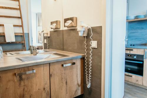 a kitchen with a sink and a phone on the wall at Hotel De Zeeuwse Kust (family only) in Renesse