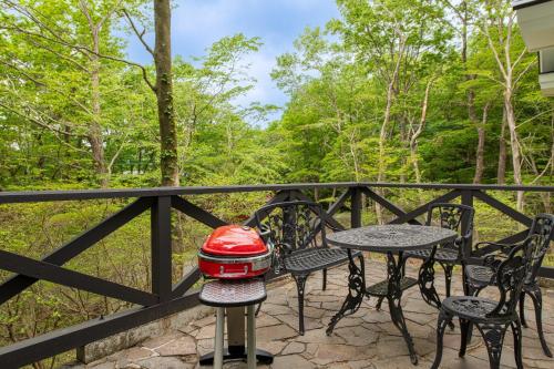 a grill on a table on a balcony with trees at S-villa那須Audrey in Nasu
