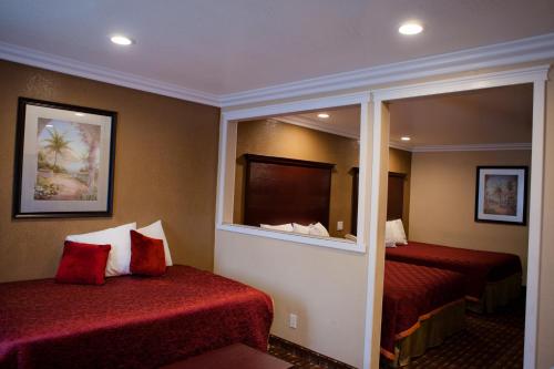 a hotel room with two beds and a mirror at Budget Inn Anaheim near Disneyland Drive in Anaheim