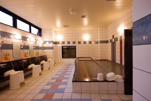 a large bathroom with a tub and sinks and mirrors at Kyoto Plaza Hotel in Kyoto