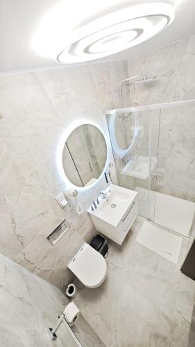 a white bathroom with a sink and a mirror at Noclegi Ewelina in Nowa Ruda