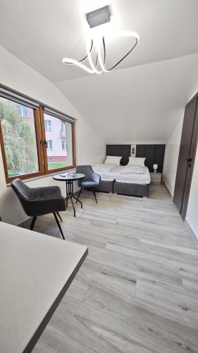 a room with a bed and a table and chairs at Noclegi Ewelina in Nowa Ruda