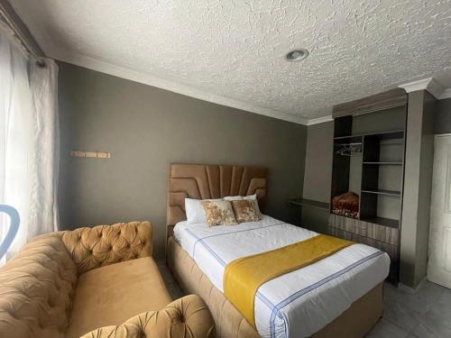 a bedroom with a large bed and a couch at Alamaison in Umtali