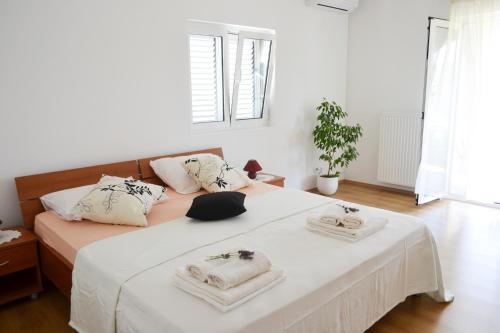 a bedroom with a bed with two towels on it at Black and White Spacious Apartment in Hvar