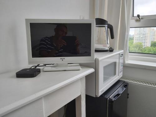 a television sitting on a table with a microwave at sky home room 2 in Amsterdam