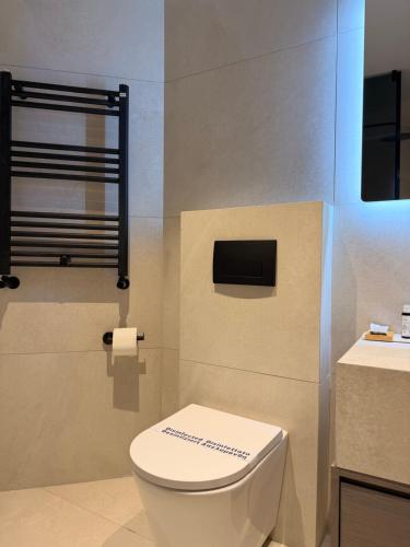 a bathroom with a white toilet and a sink at Aegean Residence #A - F & B Summer Collection in Kallithea Halkidikis