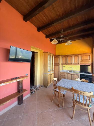 a kitchen with a table and chairs and a tv at Casa Vacanze Panoramika Santa Cruz - Appartamento PANORAMIKA in Cicerale
