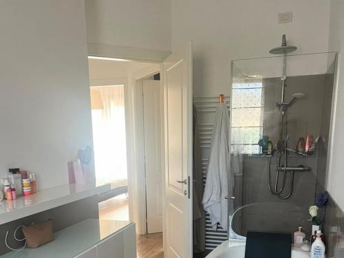 a white bathroom with a shower and a sink at Nice villa with pool and garden in Fermignano