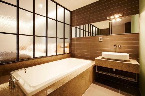 a bathroom with a bath tub and a sink at MD HOTEL Dongtan in Hwaseong