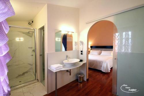 een badkamer met een wastafel, een douche en een bed bij Sangallo Hotel in Monte San Savino