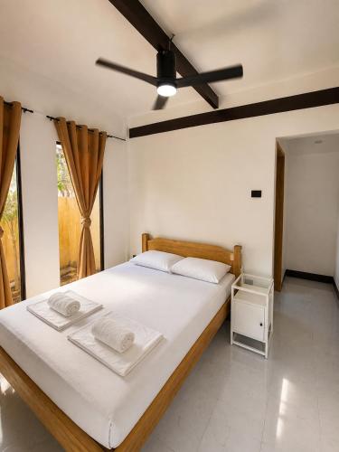 ein Schlafzimmer mit einem Bett und einem Deckenventilator in der Unterkunft MHARI Guest Rooms in San Juan