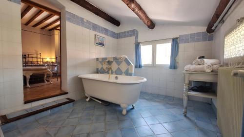 a bathroom with a white tub and blue tiles at La Bergerie Du Moulin - Espace sans enfants in Taradeau