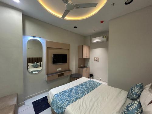 a bedroom with a bed and a flat screen tv at Hotel Prime Elite in Ahmedabad