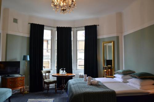 a bedroom with two beds and a table and a chandelier at Leopold Boutique Hotel in Östersund