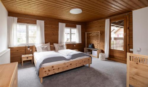 a bedroom with a bed in a room with wooden walls at Gästehaus Kaufmann in Mellau
