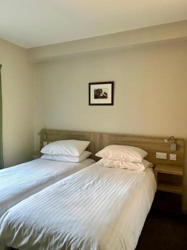 two beds sitting next to each other in a bedroom at Riverstone Lodge Hotel in Perth