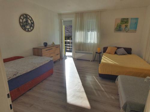 a bedroom with two beds and a dresser and a window at HH Klara in Ozalj