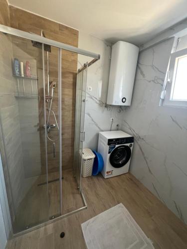 a bathroom with a shower and a washing machine at SunnyBar in Bar
