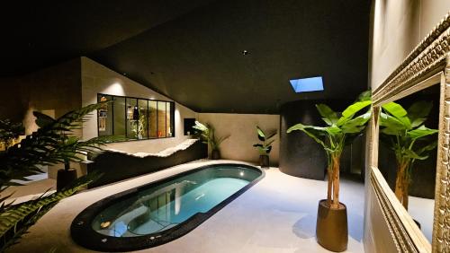 a swimming pool in a room with plants in it at Hôtel Ancre Marine & Spa Thalgo *** in Noirmoutier-en-l'lle