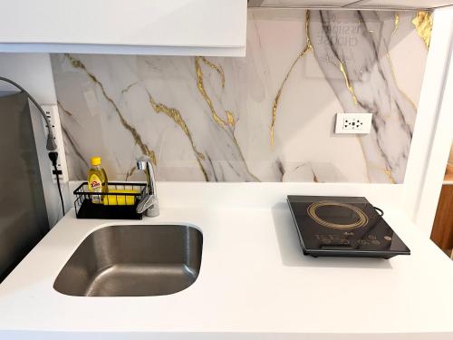 a kitchen counter with a sink and a toaster at Nest & Rest Suites Azure North in San Fernando