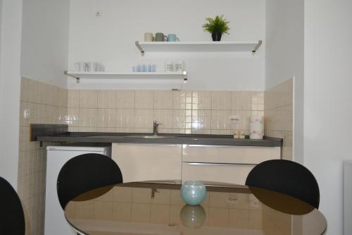 a kitchen with a sink and a table with a vase at Black and White Spacious Apartment in Hvar