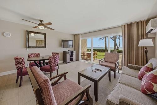 a living room with a couch and a table at Oceanfront Escape Pono Kai Resort A103 in Kapaa