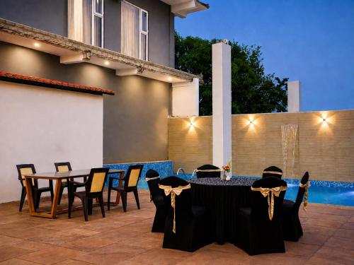 a patio with a table and chairs and a pool at Aadhya Hotel & Adhira Restaurant in Orchha