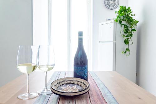 a bottle of wine and two glasses on a table at Casa Nel Blu in SantʼAlessio Siculo