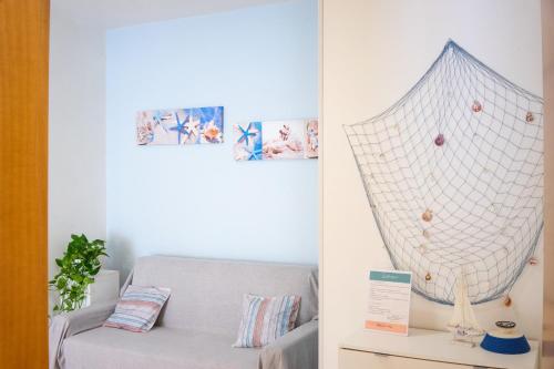 a living room with a couch and a net at Casa Nel Blu in SantʼAlessio Siculo