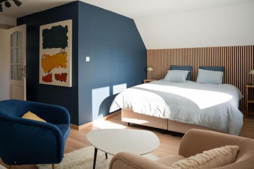 a bedroom with a bed and a blue wall at Rouges Terres in Theux