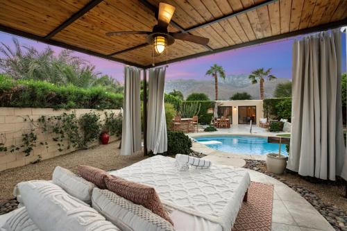 a patio with a couch and a ceiling fan at Adobe Barona Dream in Palm Springs
