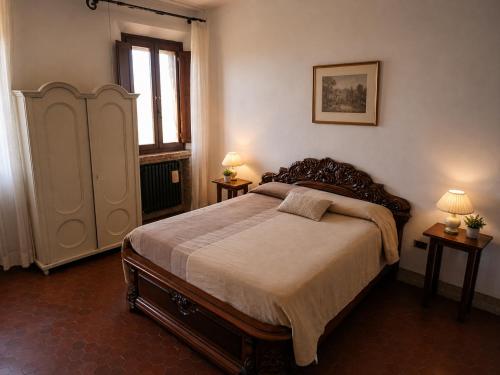 a bedroom with a large bed and two lamps at Locanda Corte Arcangeli in Ferrara