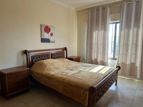 a bedroom with a bed and a window with curtains at شقق الخامسه الفاخرة Al Amer Luxury Apartments in Aqaba